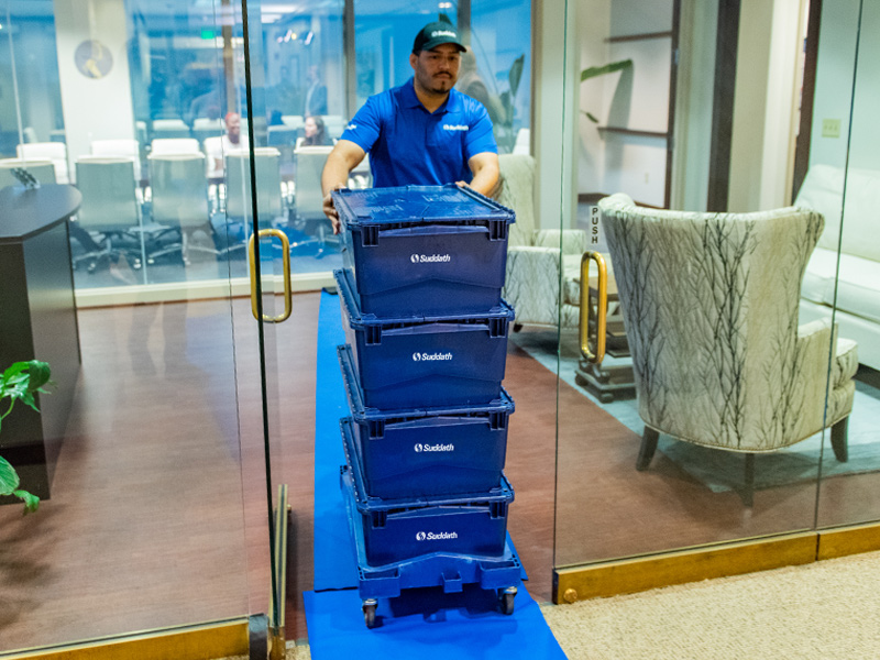 office mover pushing reusable moving crates